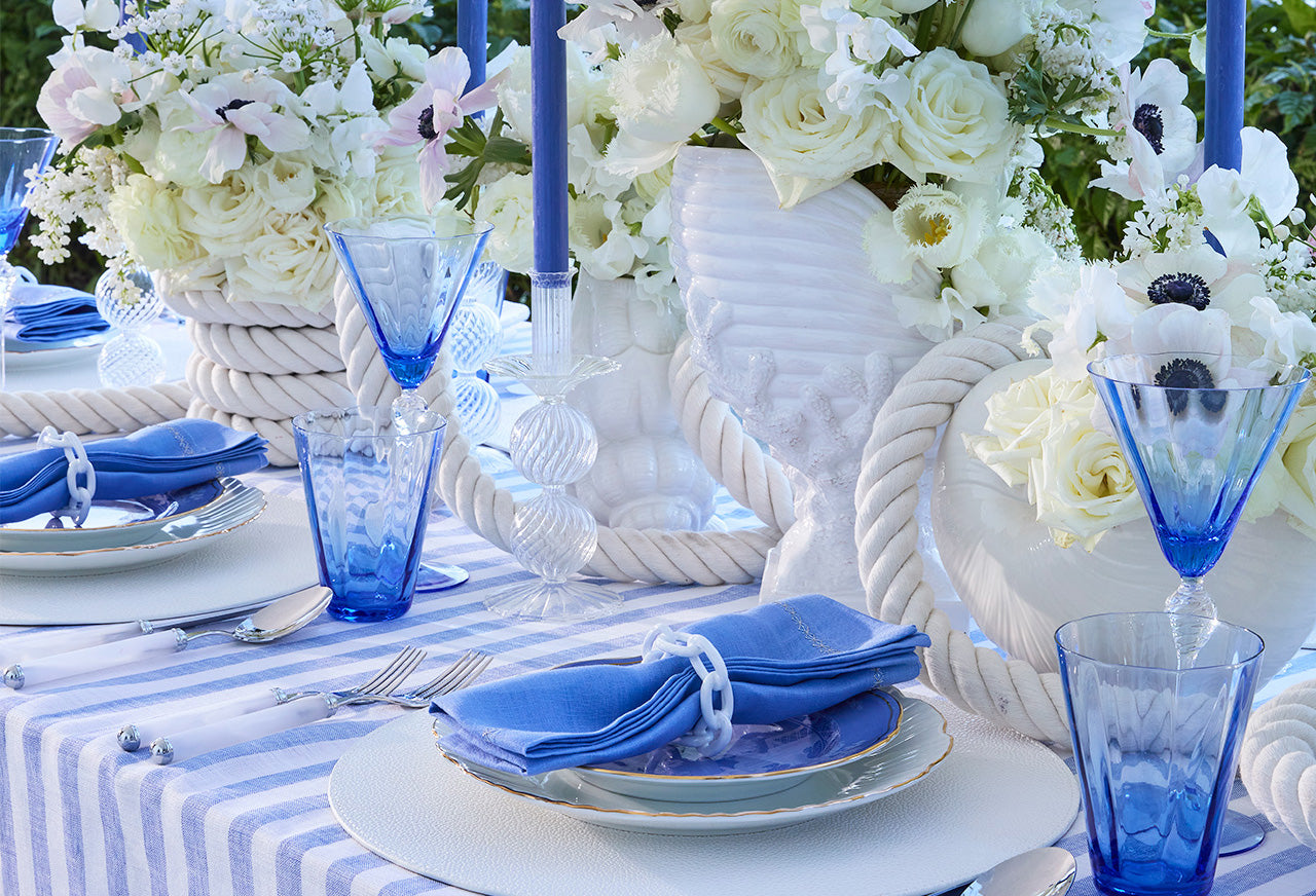 Tall vases on a nautical tablescape with blue glassware and table linens
