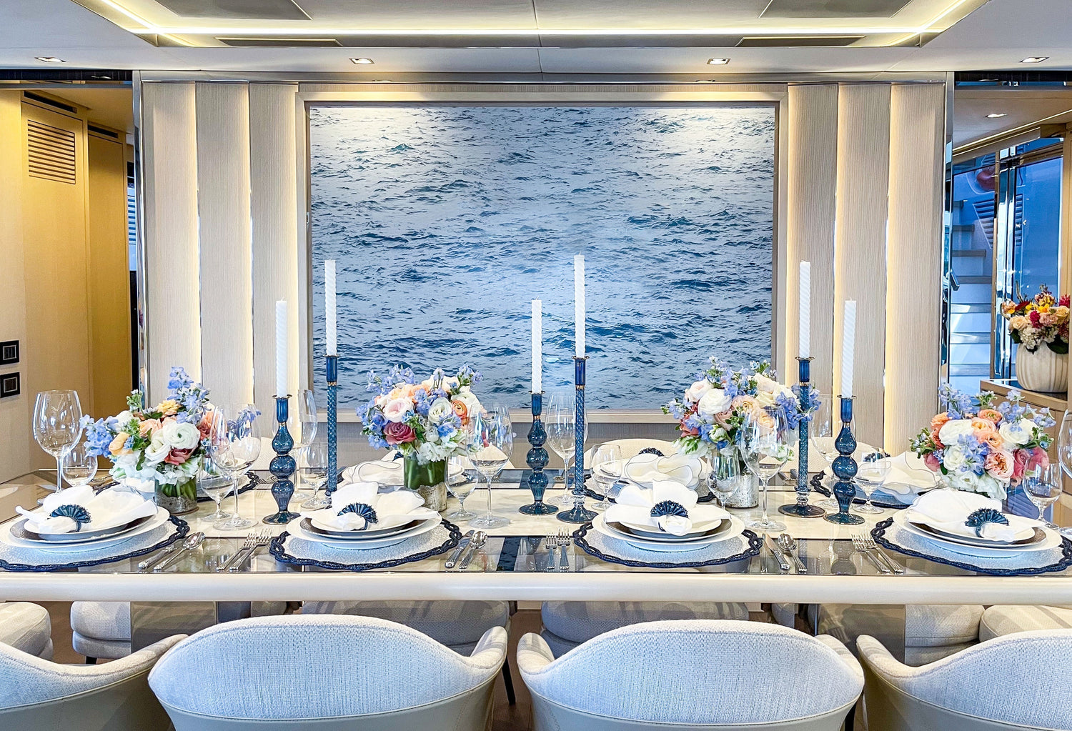 Elegant yacht table decor with nautical designs, navy blue linens, and high-end glassware by Kim Seybert