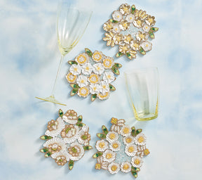 Set of four beaded Kim Seybert Luxury Gardenia Drink Coasters in Sky, White, & Yellow
