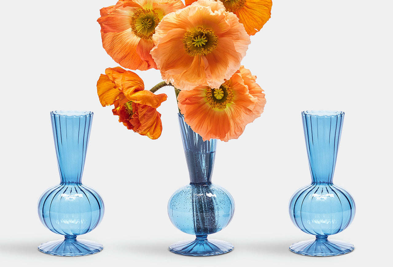 blue glass bud vases orange floral arragements