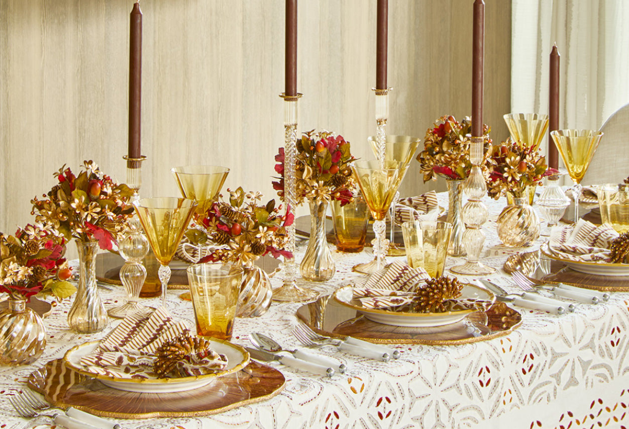 Friendsgiving ideas for fall tables styled with warm-toned decorations, floral centerpiece, and dinnerware
