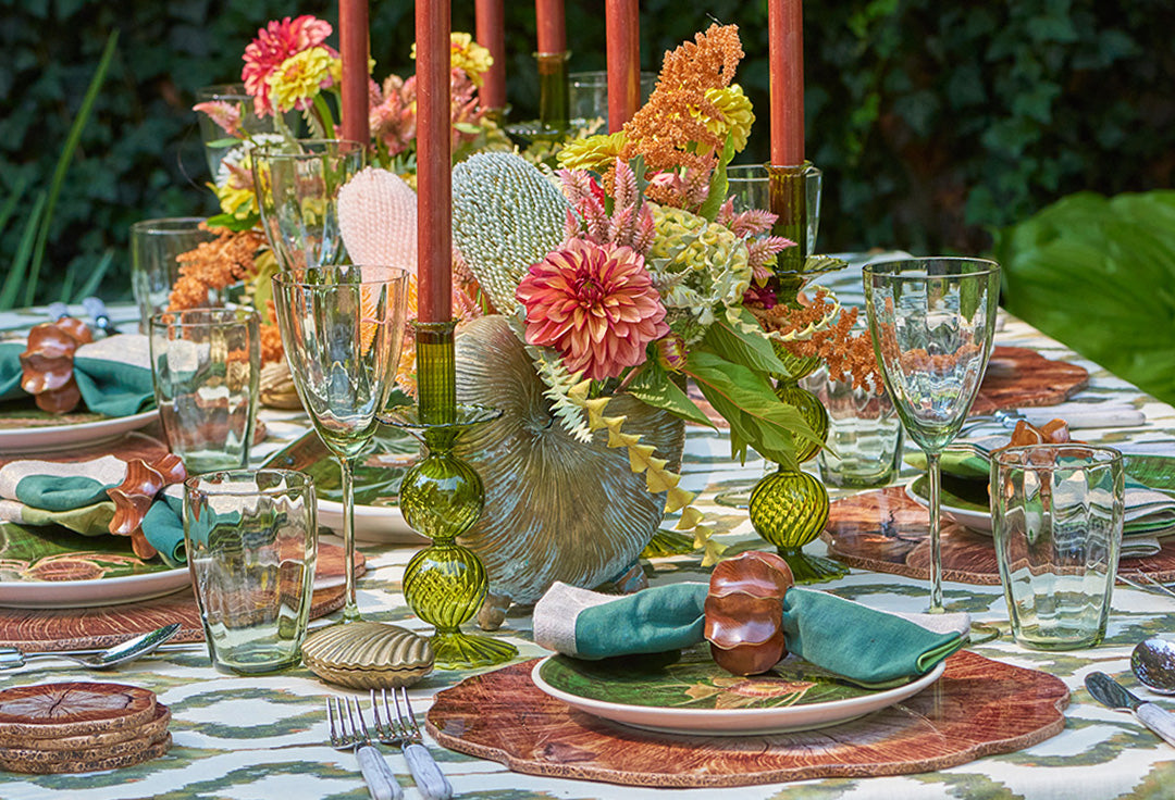 Luxury New England fall tablescape styled outdoors with autumn foliage, layered Kim Seybert table linens, candles, and seasonal decor.