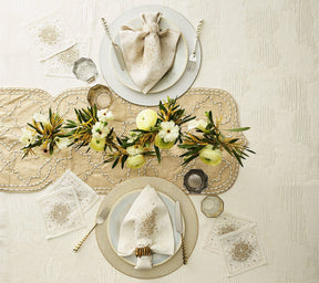Luxury Starburst Cocktail Napkins in White, Gold & Silver, shown on a table with gold place settings and floral arraangement