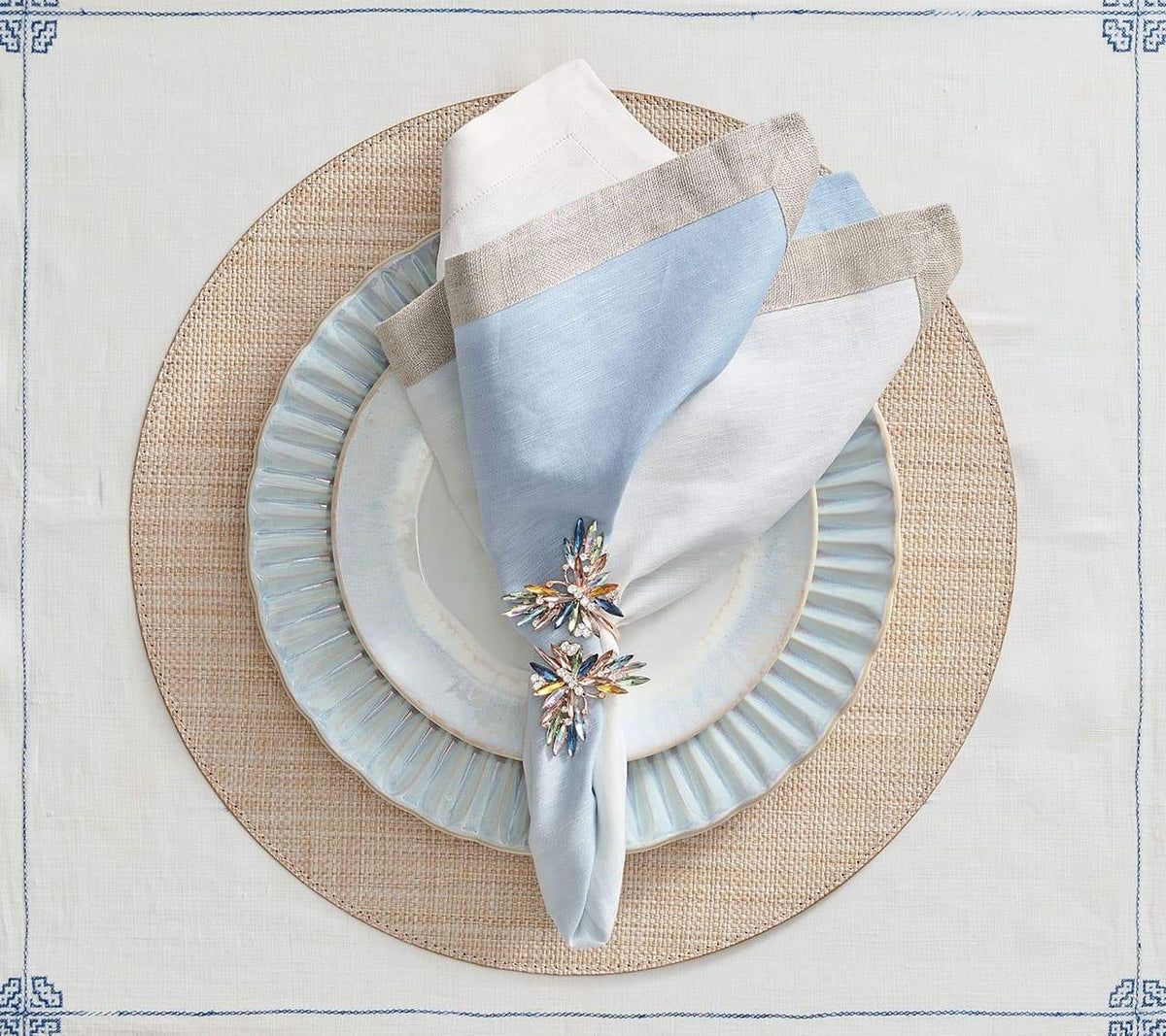 Round Portofino Placemat in natural underneath blue and white plates topped with a blue & white napkin