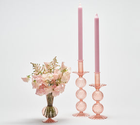 Kim Seybert Luxury Bella Short Candle Holder in blush next to a vase with blush flowers