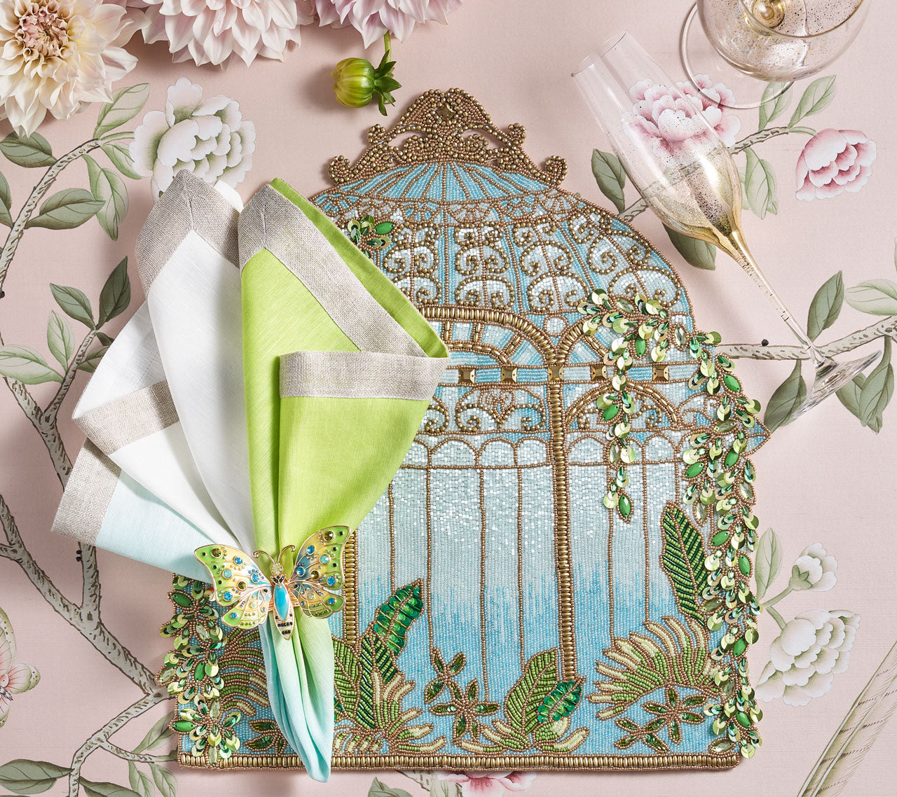 Beaded Arbor Placemat with a blue-green ombre napkin  held by a butterfly napkin ring, placed on the side
