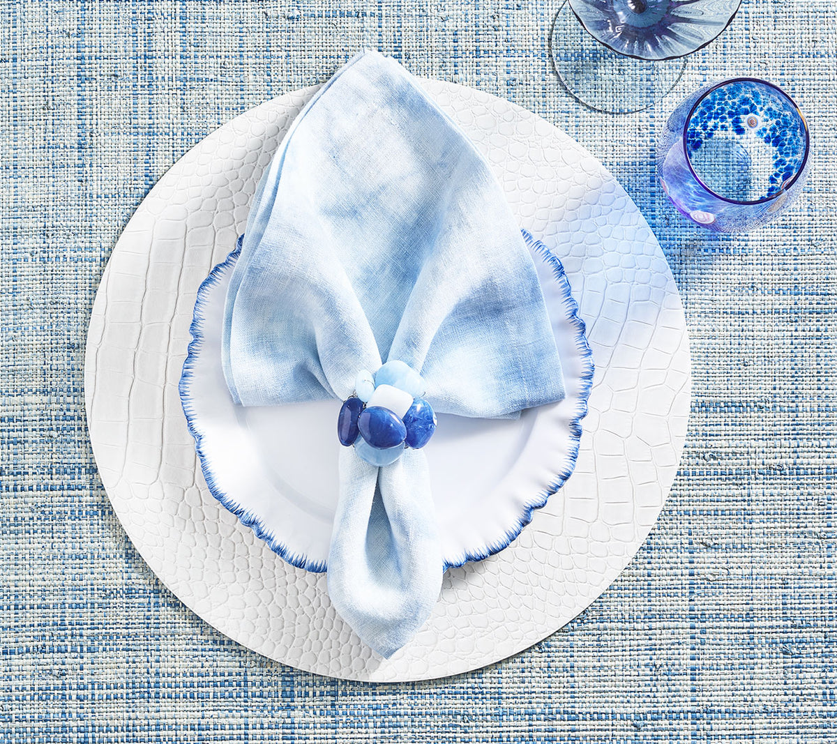 Periwinkle Cloud Napkin on top of a white placemat and plate