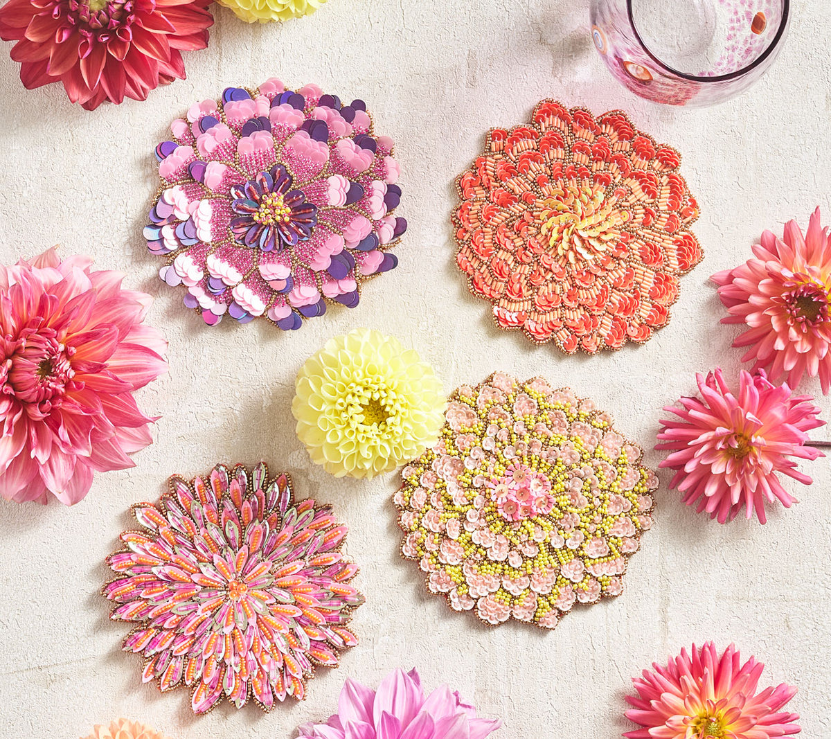 Kim Seybert Luxury Dahlia Drink Coasters mixed with flowers on a table