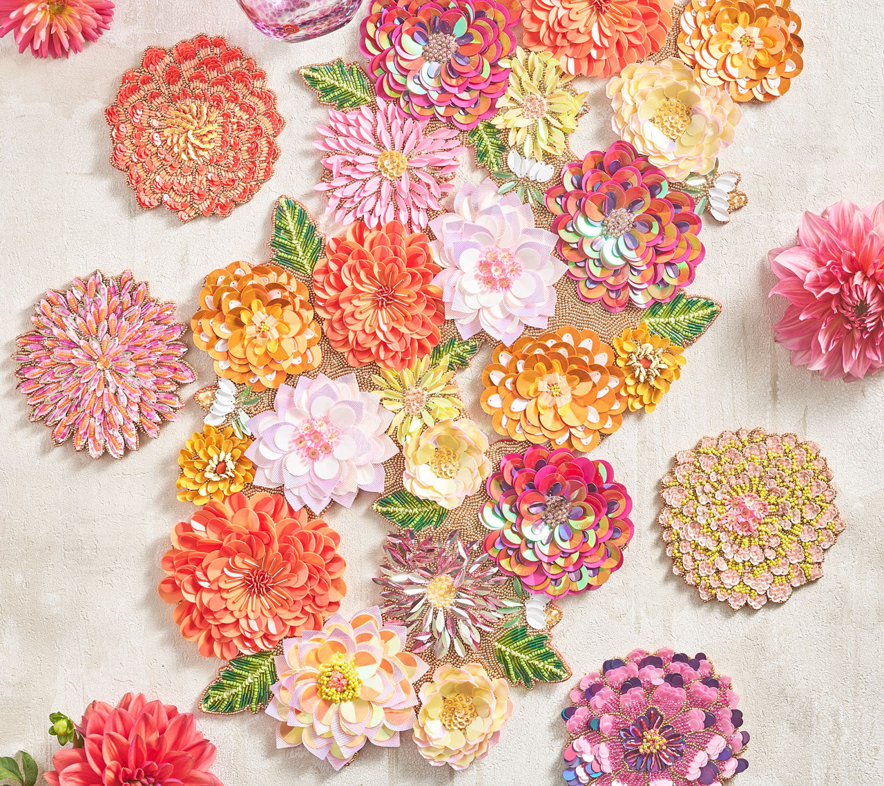 Beaded Dahlia Runner in tones of pink, orange and amethyst shown with floral drink coasters