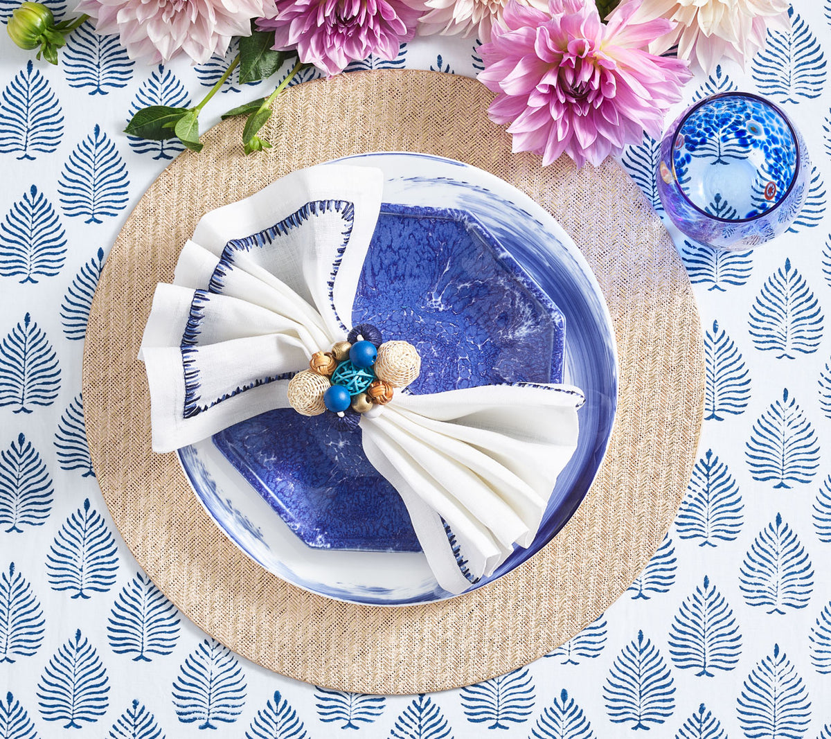 Java Napkin Ring holding a napkin with a blue border on top a blue plate
