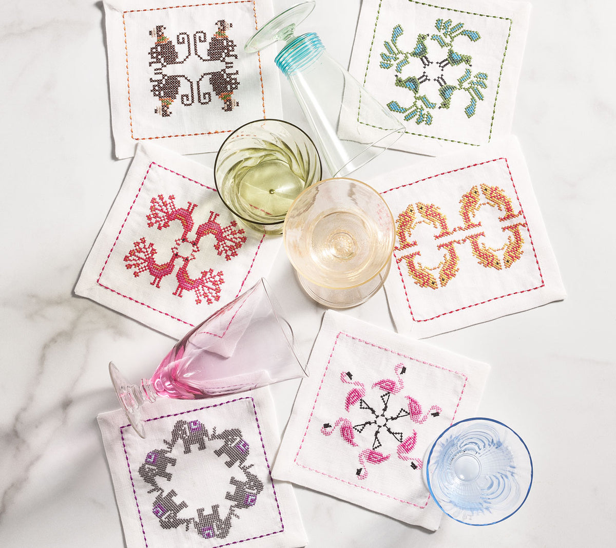 Kim Seybert Luxury Menagerie Cocktail Napkins, set of 6 on a table with drink glasses