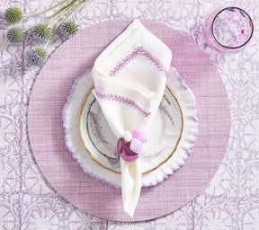 Overhead view of a lilac place setting with Kim Seybert Luxury Jardin Napkin in white & lilac
