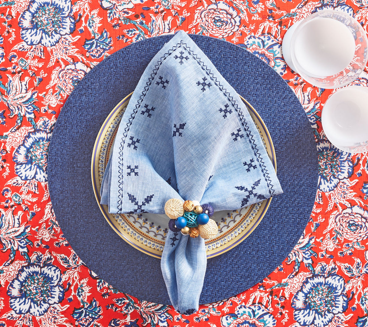 Red & blue tablecloth with a blue placemat below a periwinkle Fez Napkin 
