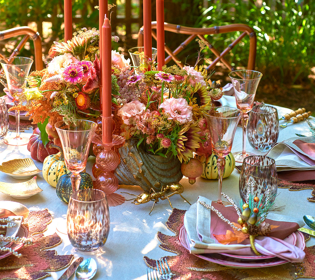Kim Seybert Luxury Bella Short Candle Holder in blush featured on a table outside 