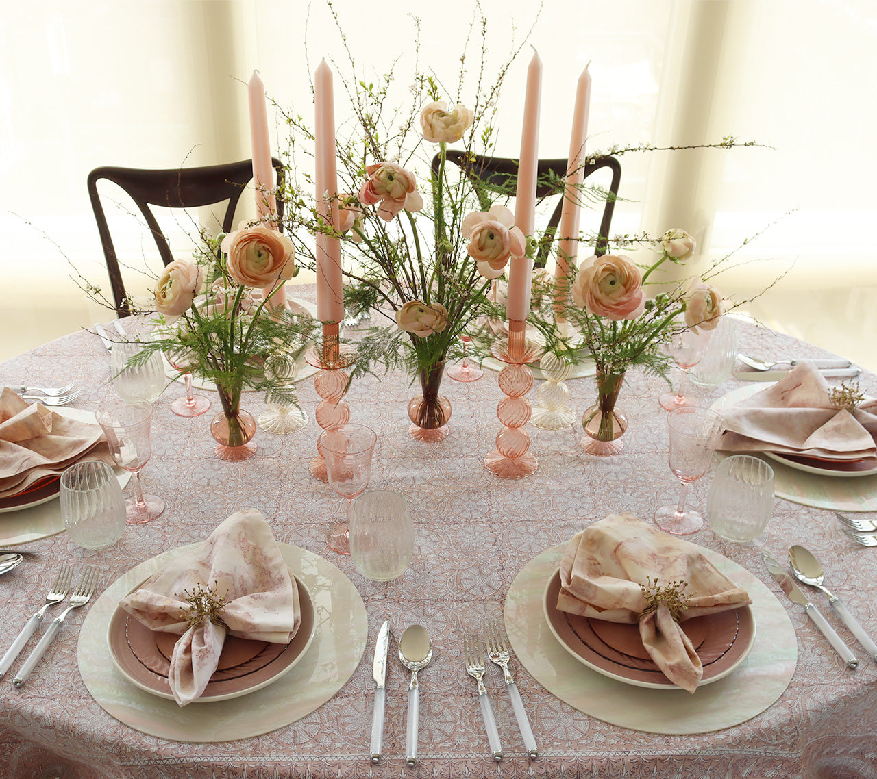 Table with pink place settings and a center filled with Bella Candlesticks and Tess Bud Vases in blush