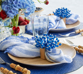Table with blue flowers, strawberries, wooden plates and Saigon Placemats in navy