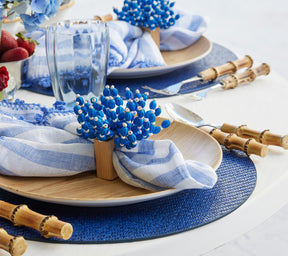 Side view of the blue & white  Reed Napkin Ring  on a wooden plate