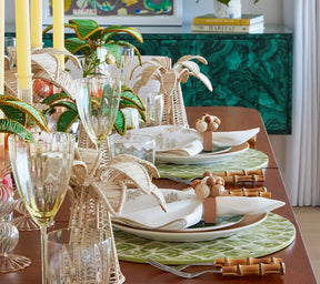 Side view of a wooden table set with Fern Placemats in ivory & green and bamboo cutlery