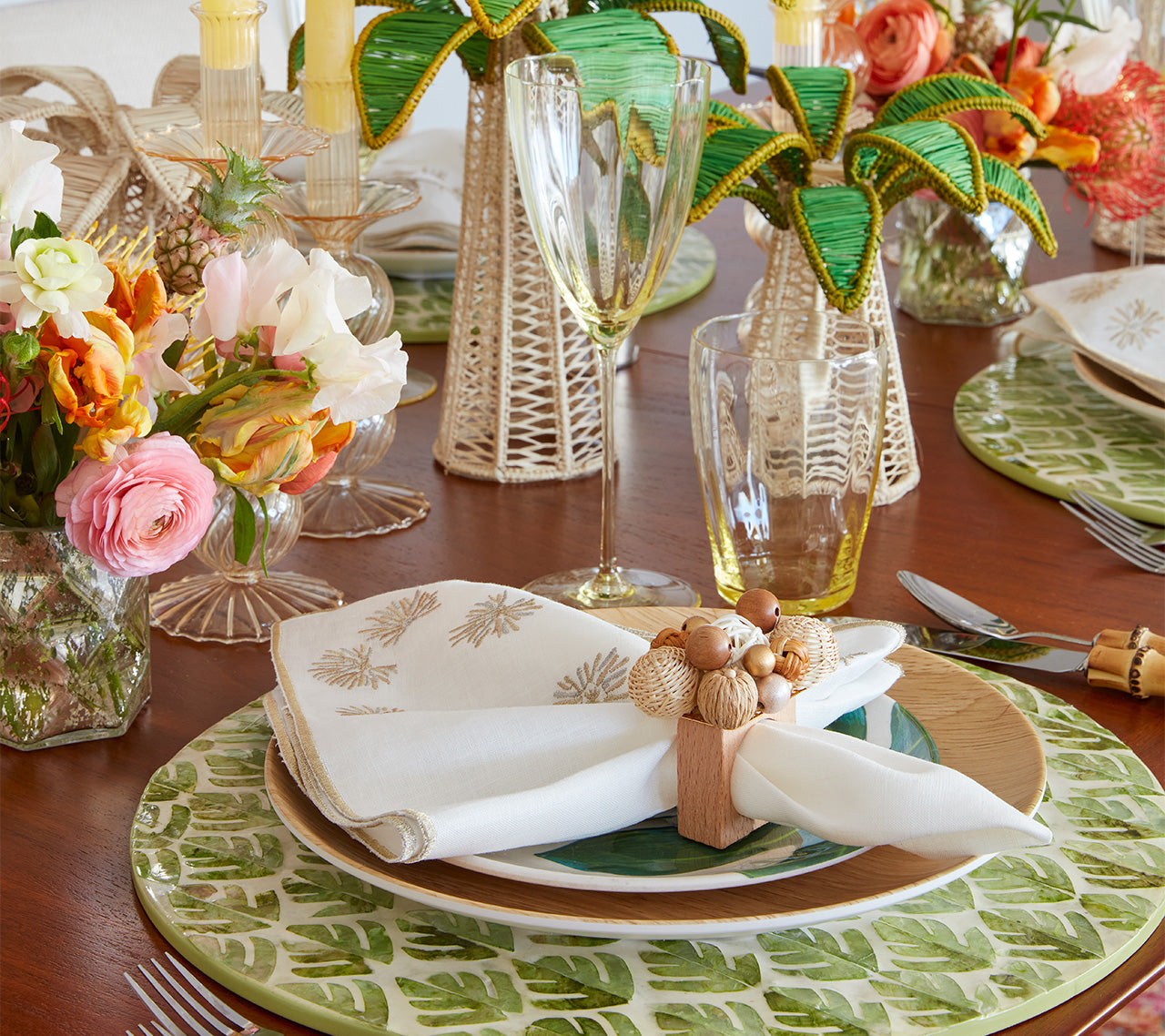 Table setting of a Fern Placemat in ivory & green with a natural wood napkin holder on a wood table