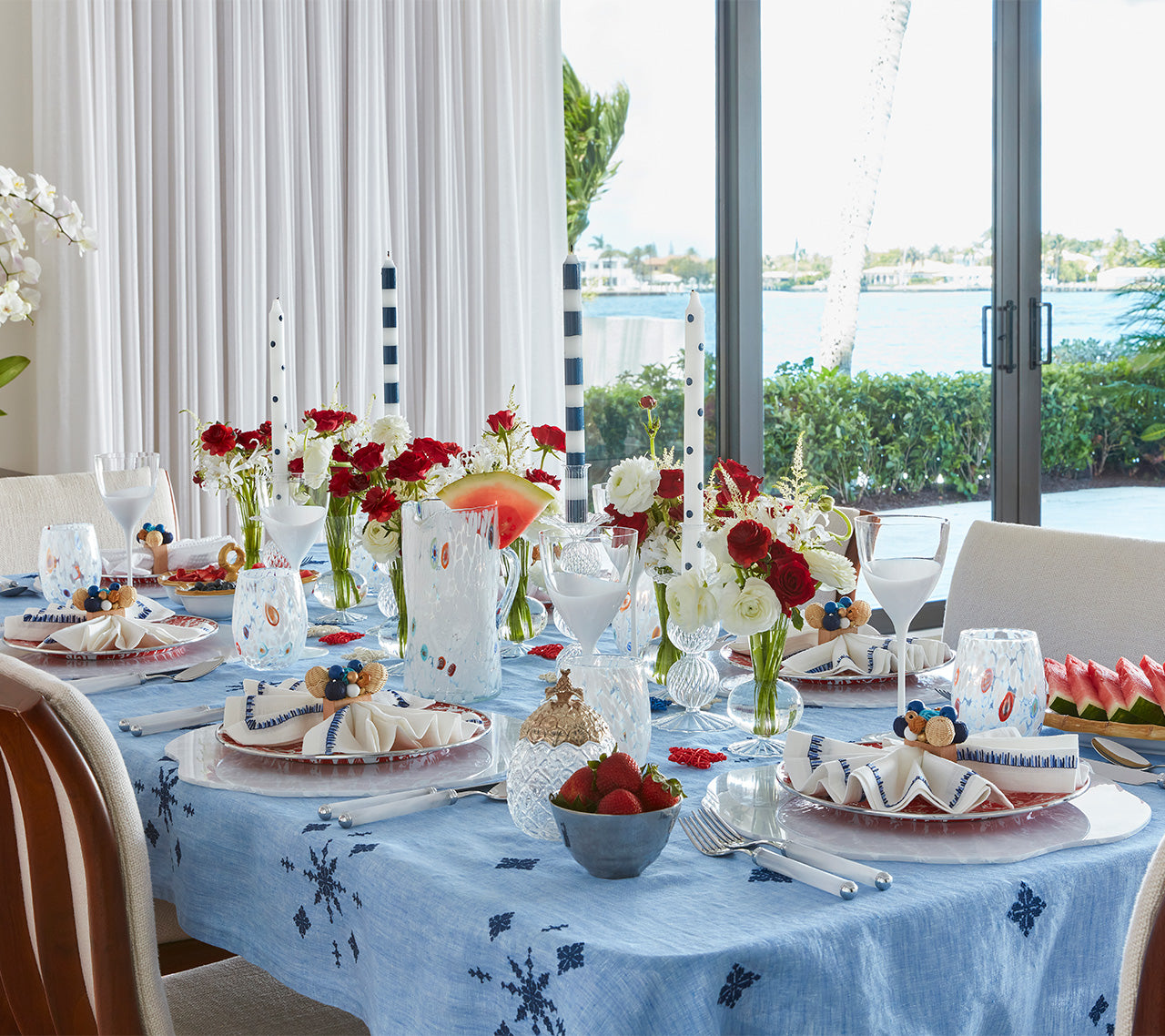 Table set with the Fez Tablecloth in periwinkle and navy and colorful accents like strawberries in blue bowls, watermelon,  and red & white flowers