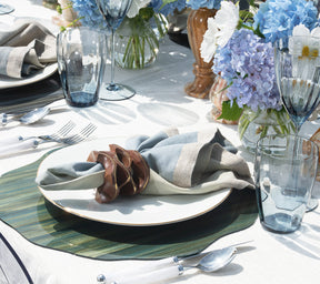 Kim Seybert Luxury Dip Dye Napkin in natural & seafoam on a plate and a green placemat