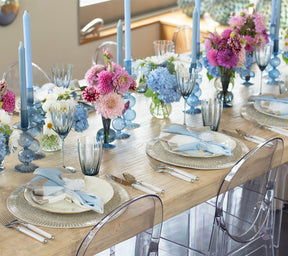Kim Seybert Luxury Bella Short Candle Holders in cadet on a table with pink and blue flowers